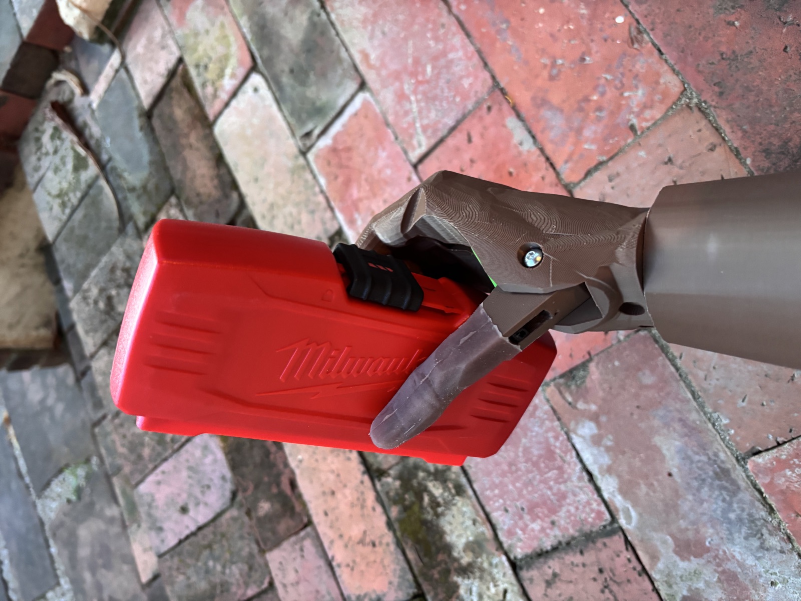 A printed hand gripping a red tool case